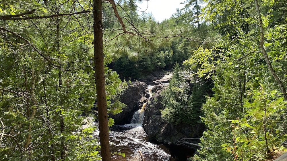 Copperfalls waterfall through foliage